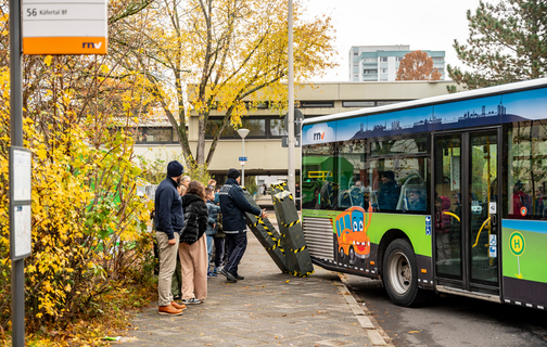 Der Bus der rnv-Busschule beim Ausparken von der Haltestelle: Das Heck des Busses fährt über einen Teil des Gehwegs und streift dabei die dafür aufgestellten Dummys, die dadurch umfallen.