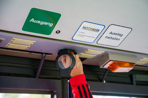 Eine Person betätigt den Nothahn des Busses der rnv-Busschule, um zu zeigen, wie in einem Notfall die Bustür zu öffnen ist.