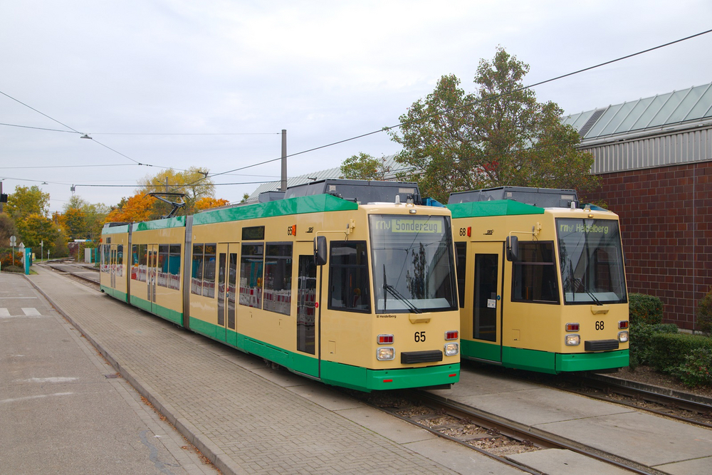 Zwei beige-grüne Straßenbahnen stehen nebeneinander im Betriebshof in Ludwigshafen-Rheingönheim. Demnächst werden sie nach Schoneiche bei Berlin transportiert.
