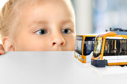 Kind betrachtet Bus- und Straßenbahn-Modelle