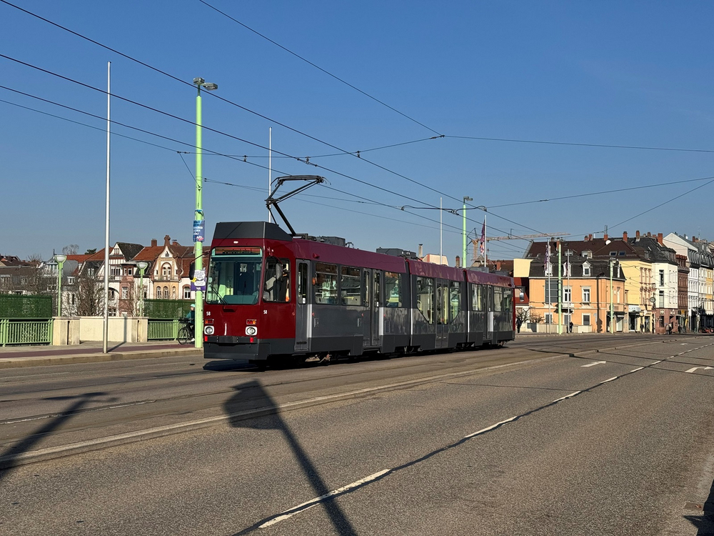 Eine grau-rote Bahn steht auf einer großen Brücke in Heidelberg.