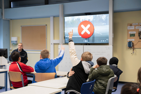 Eine Schulklasse im Klassenzimmer beim Filmquiz zum richtigen und sicheren Verhalten im ÖPNV.