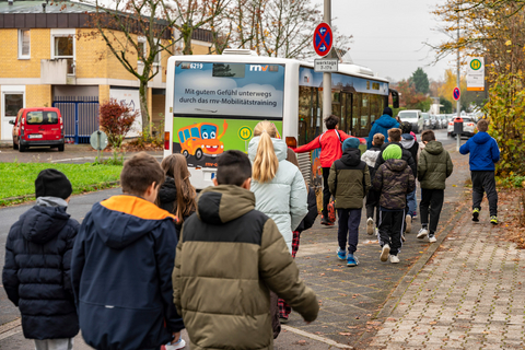 Eine Schulklasse vor dem Bus der rnv-Busschule an der Haltestelle für den Schulbus ihrer Schule.