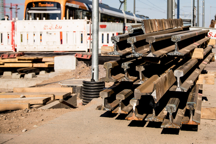 Aufgeschichtete Gleise neben einer Straßenbahn der rnv