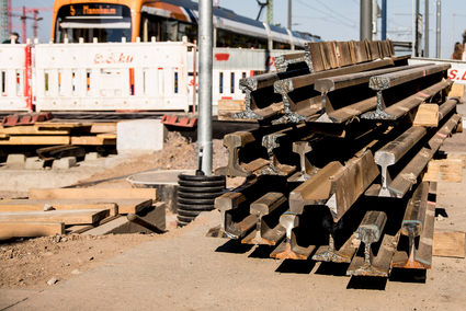 Aufgeschichtete Gleise neben einer Straßenbahn der rnv